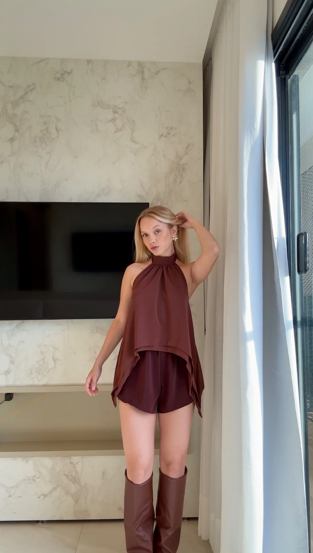 Blusa Ayla em tecido poliéster com gola alta e amarração.